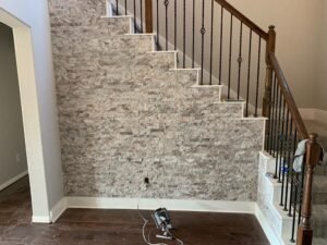 Home Stacked stone accent wall under staircase after by Mesk LLC